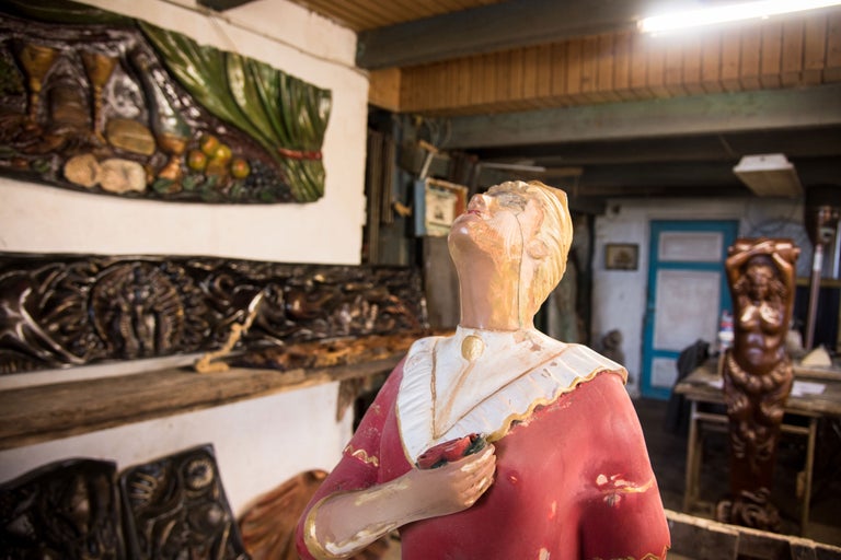 Szene mit handgefertigten Holzskulpturen und Holzschnitzereien an den Wänden.