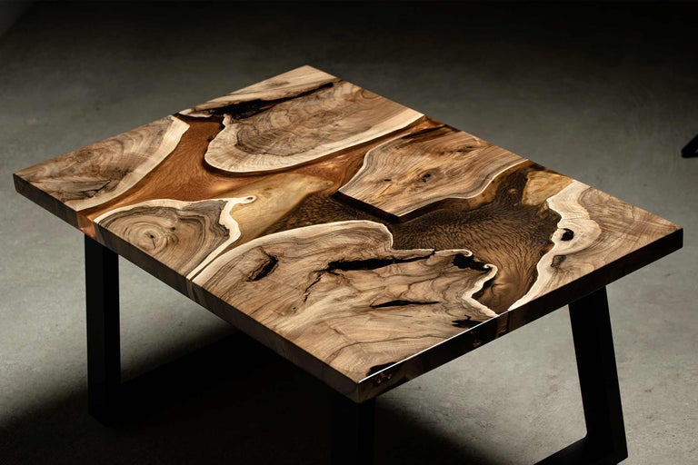 Tisch mit Holzplatte und Epoxidharz auf schwarzem Metallgestell