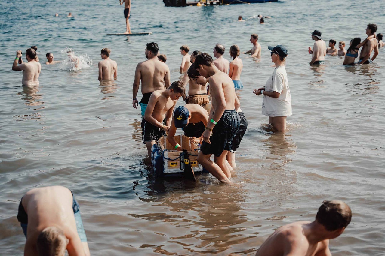 Eine Gruppe von Menschen steht im Wasser, um ein Floß zu bauen.
