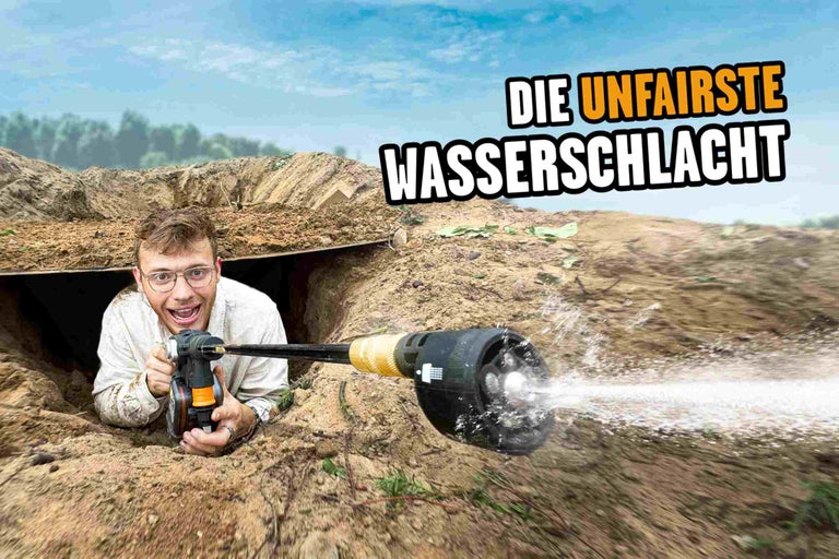 Mann in einem Erdloch mit einer Gartenspritze für eine Wasserschlacht