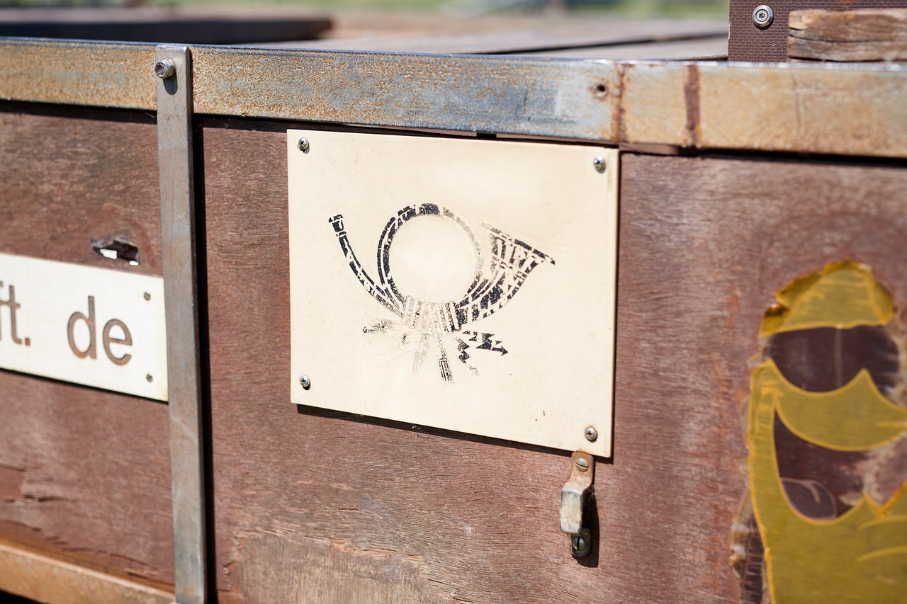 Posthornsymbol auf Holzstruktur