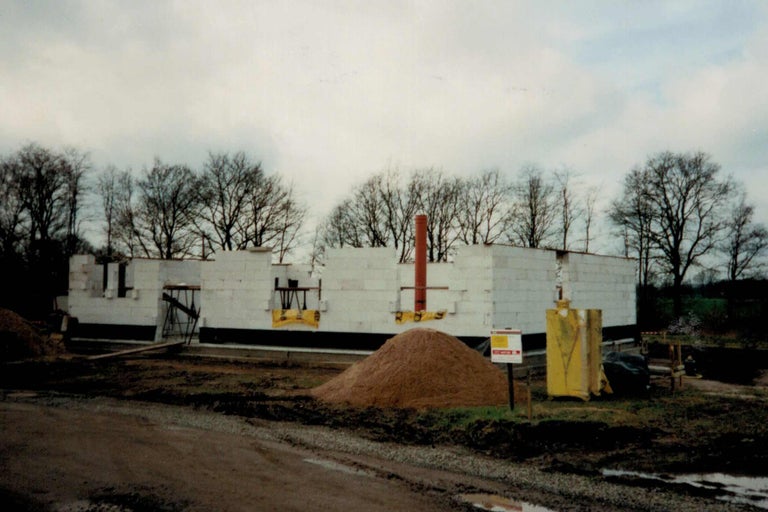 Rohbau eines Hauses mit Porenbetonsteinen und einem Sandhaufen im Außenbereich
