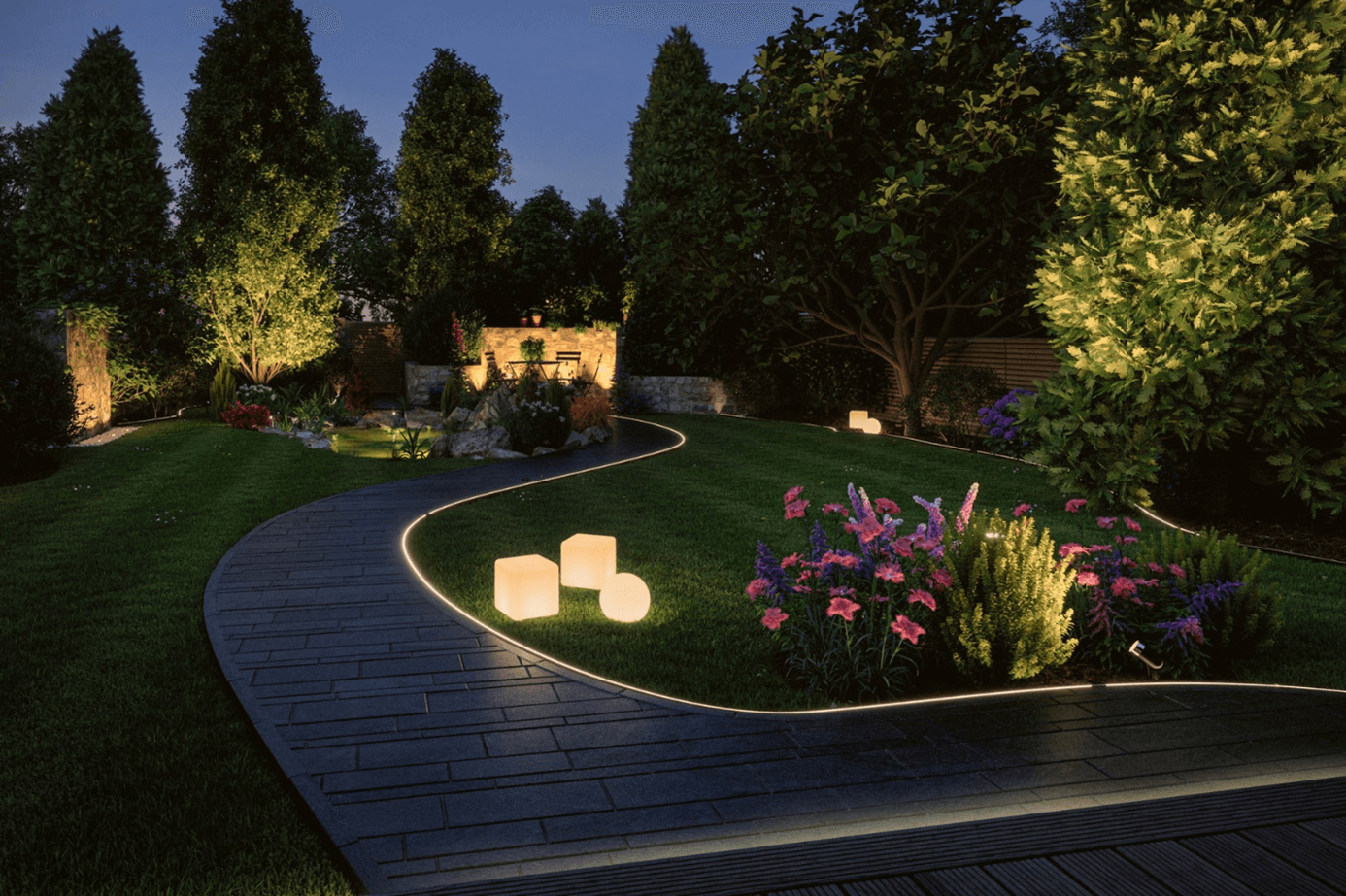 Beleuchteter Garten mit Weg, Rasen und Pflanzen bei Nacht