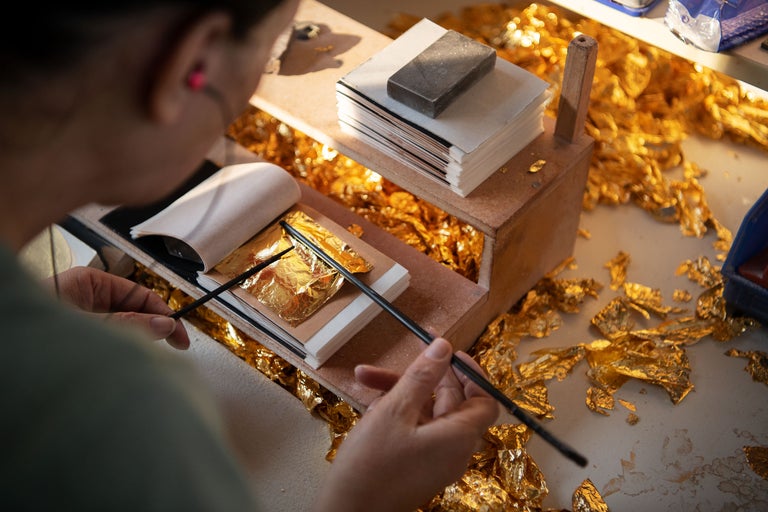 Vergolderin bei der Arbeit mit Blattgold und Vergoldewerkzeug