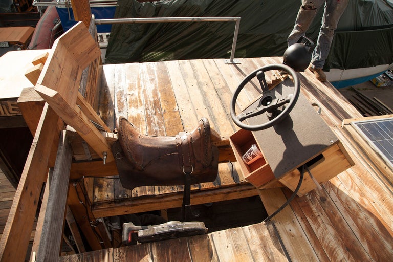 Detailansicht eines selbstgebauten Fahrzeugs mit Lenkrad, Sattel und Holzkonstruktion