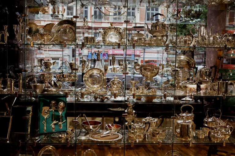 Vitrine mit silbernen Serviergeschirren und Tischdekorationen