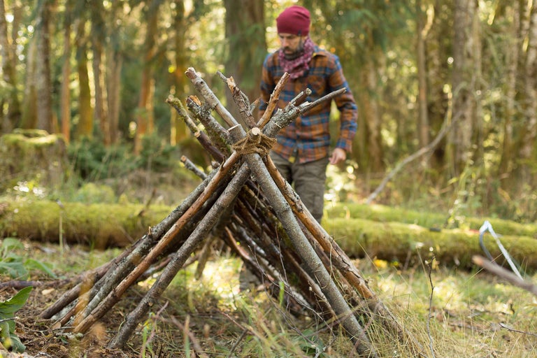 Behelfsmäßige Unterkunft aus Ästen im Wald, ideal für Outdoor Aktivitäten