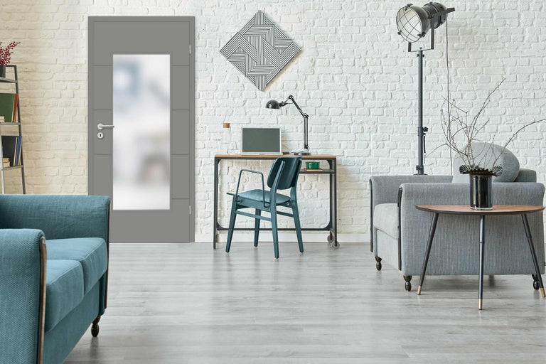 Modernes Wohnzimmer mit grauer Innentür, Sofa, Schreibtisch und Dekoration