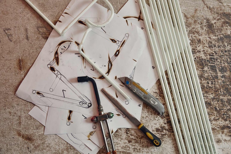 Skizzenblätter, Werkzeuge und Rohre auf einer Arbeitsfläche