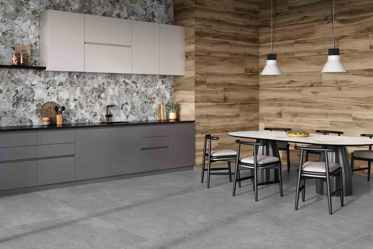 Helle, geräumige Küche mit grauen Fliesenboden, Arbeitsplatte, Rückwand und Holzwand