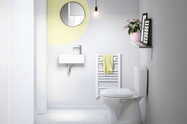 Badezimmer mit Toilette, Waschbecken, Spiegel und Heizkörper