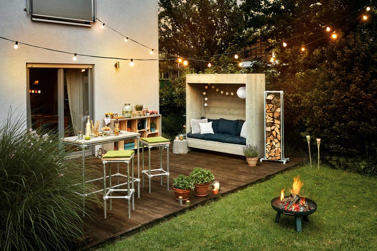 Außenbereich mit Lounge-Ecke, Hochtischgruppe und Feuerstelle für eine gemütliche Atmosphäre