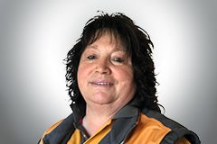 Porträt einer Frau mit dunklen Haaren und Arbeitskleidung