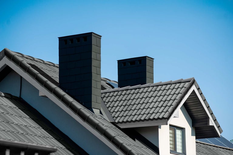 Dach eines Hauses mit Schornsteinen und Dachziegeln