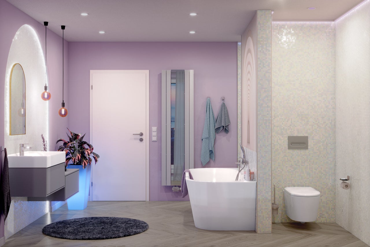 Modernes Badezimmer mit fliederfarbenen Wänden, freistehender Badewanne, Hänge-WC, grauem Waschtischunterschrank und Boden in Holzoptik.