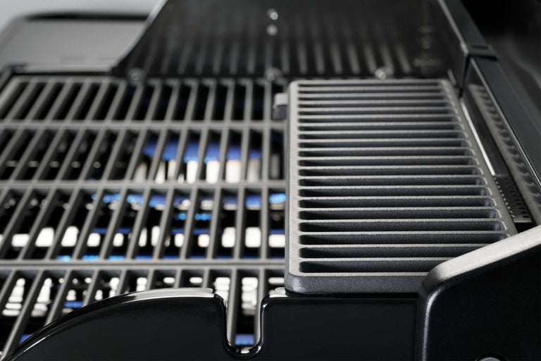 Detailaufnahme eines Gasgrills mit Grillrost und Brennern