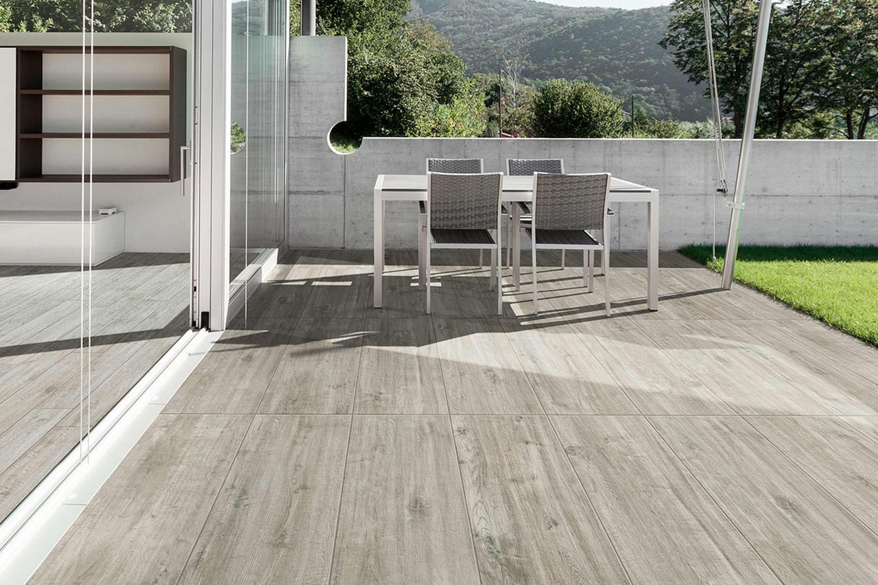 Terrasse mit Outdoor-Möbeln und Bodenfliesen in Holzoptik