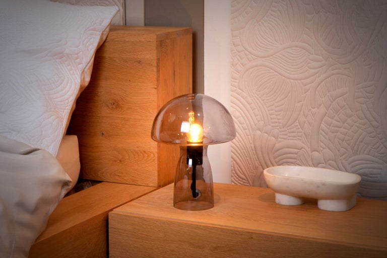 Dekorative Tischleuchte aus Glas auf einem Nachttisch im Schlafzimmer.