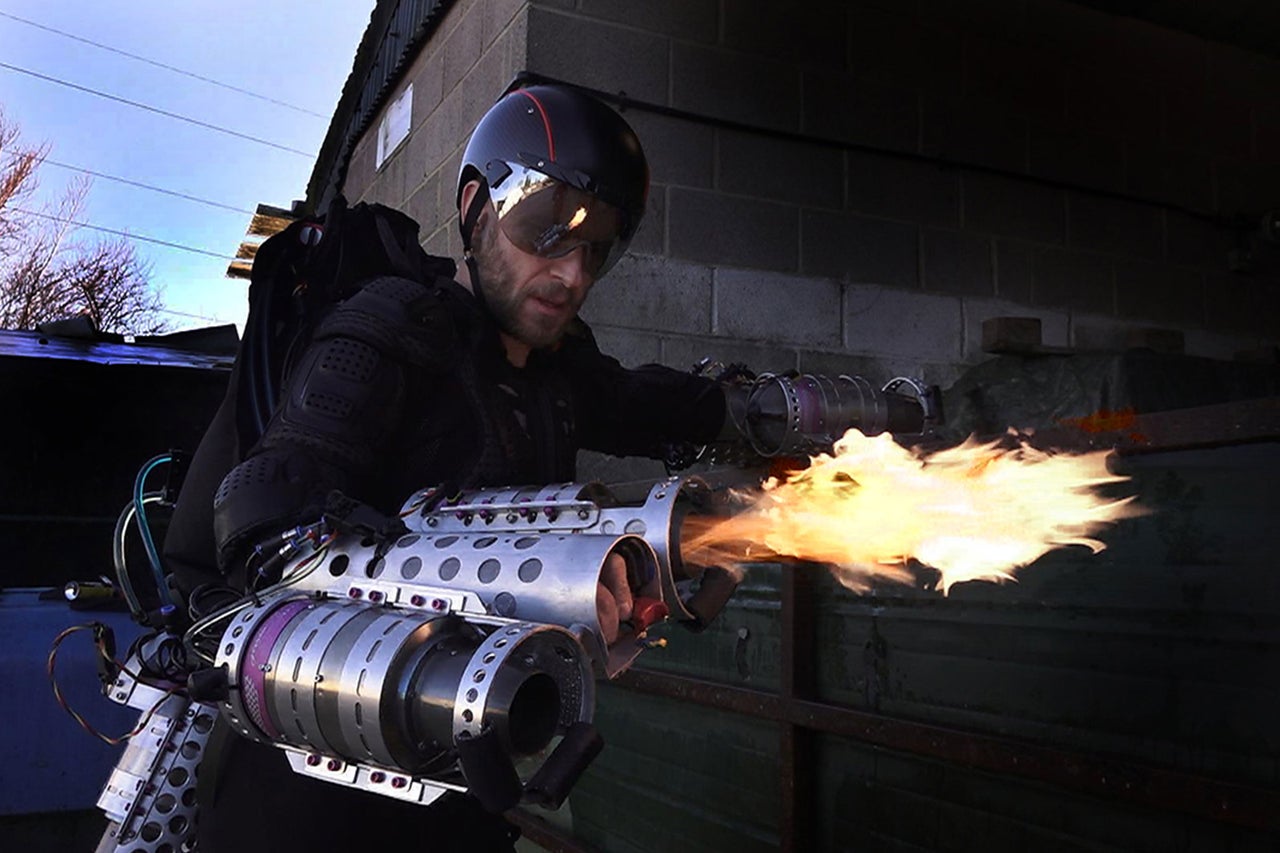 Eine Person mit Helm und Flammenwerfer-Ausrüstung