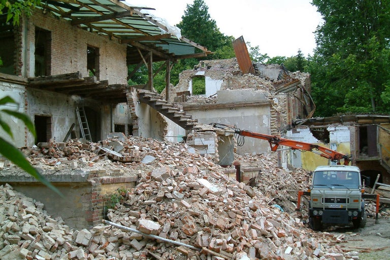 Abriss eines Gebäudes mit Bauschutt und Abrissbagger