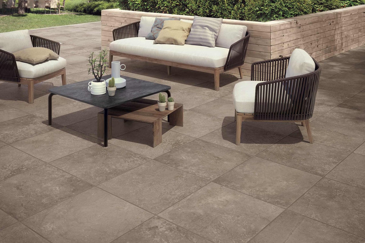 Terrasse mit Terrassenplatten, Gartenmöbeln und dekorativen Pflanzen