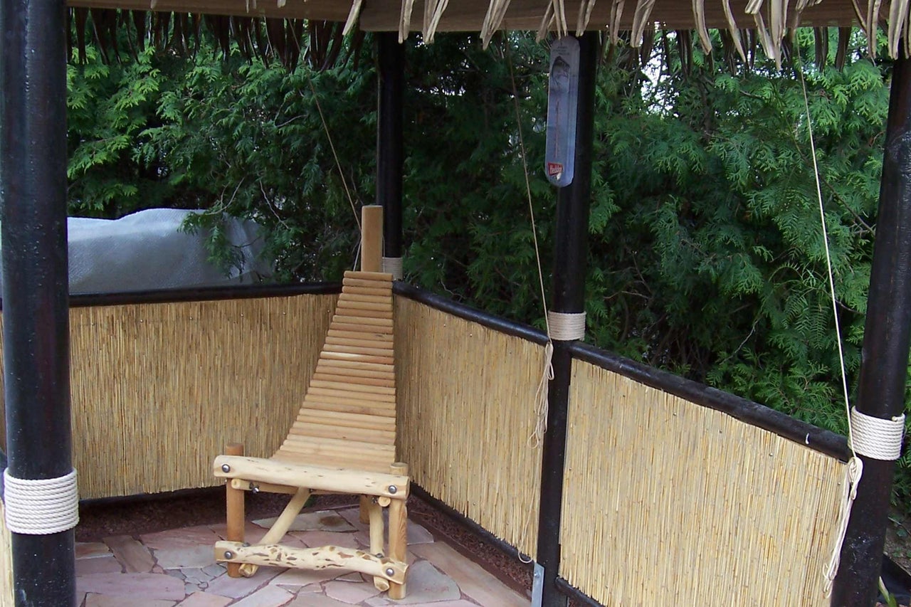 Szene einer Gartenlaube mit Bambuszaun und Holzstuhl