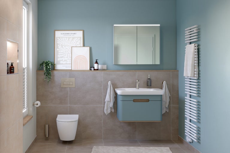 Helles Badezimmer mit Toilette, Waschtisch, Spiegelschrank und Heizkörper