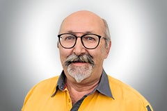 Porträt eines Mannes mit Brille und gelbem Hemd