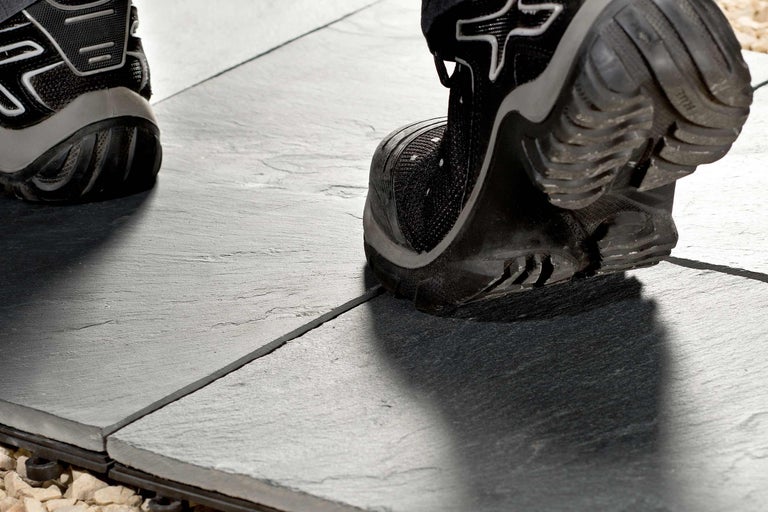 Person betritt eine dunkle Schieferplatte