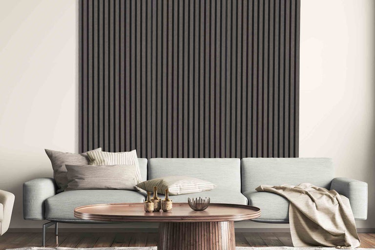 Wohnzimmer mit Akustikpaneelen an der Wand, Sofa und Couchtisch