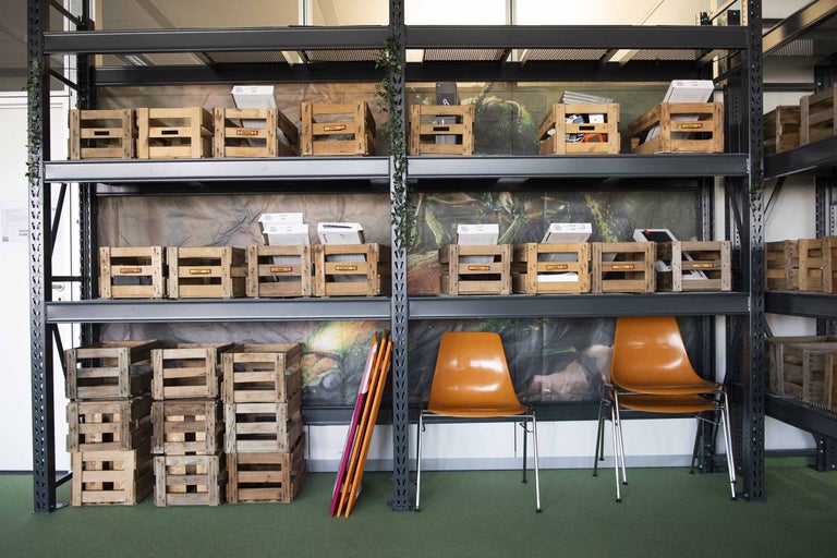 Regalsystem mit Holzkisten zur Lagerung und zwei Stühlen