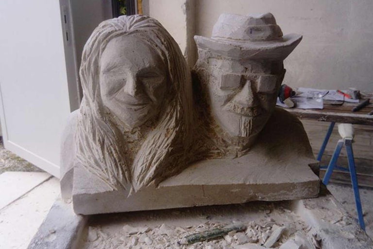 Skulptur aus Stein mit den Gesichtern einer Frau und eines Mannes