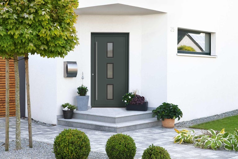 Eingangsbereich eines Hauses mit Haustür, Briefkasten und Bepflanzung