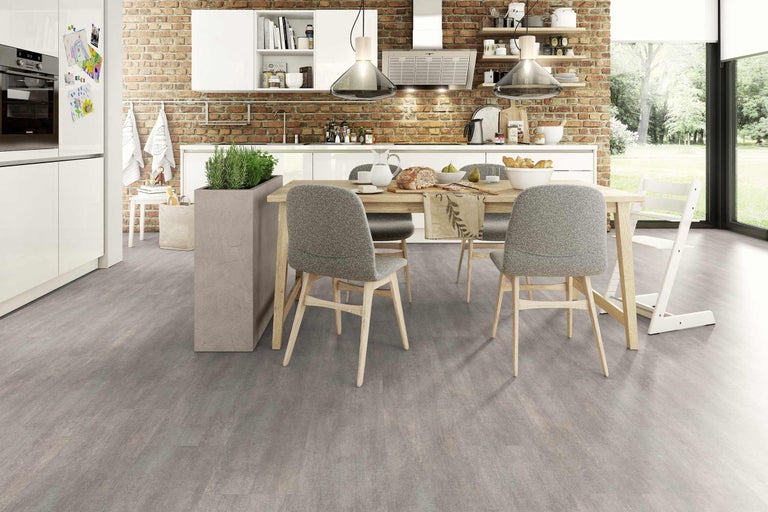 Helle, moderne Küche mit Esstisch und Stühlen vor einer Ziegelwand