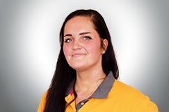 Eine Frau mit dunklen Haaren in Arbeitskleidung