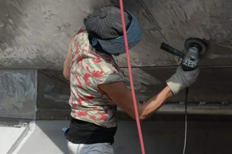 Eine Person verwendet eine Schleifmaschine zum Bearbeiten einer Oberfläche.