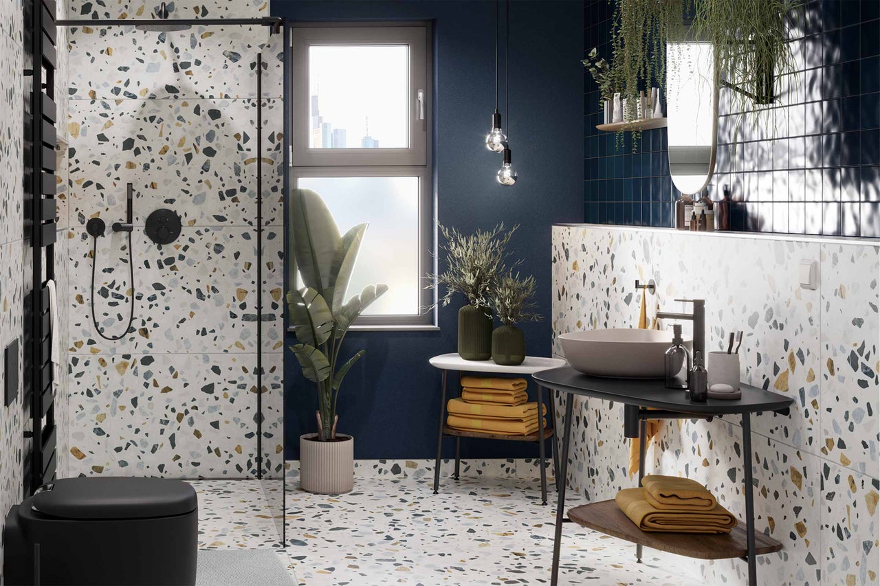 Modernes Badezimmer mit Terrazzo Fliesen, Dusche, Waschbecken und Dekorationen.
