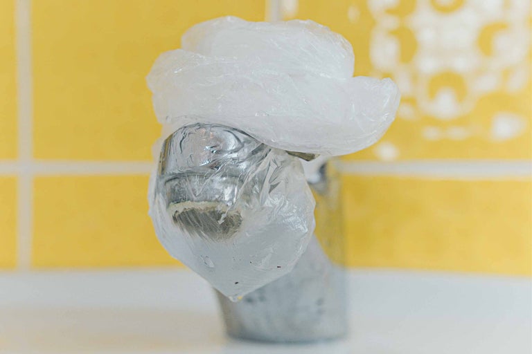 Ein Wasserhahn ist mit einer Plastiktüte abgedeckt.