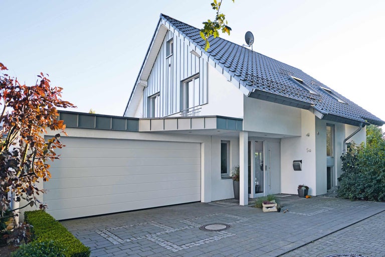 Modernes Einfamilienhaus mit Garage und gepflasterter Einfahrt