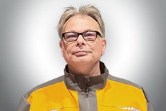 Porträt eines Mannes mit Brille in Arbeitskleidung