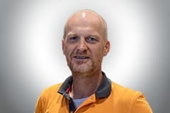 Porträt eines Mannes in einem orangefarbenen Poloshirt