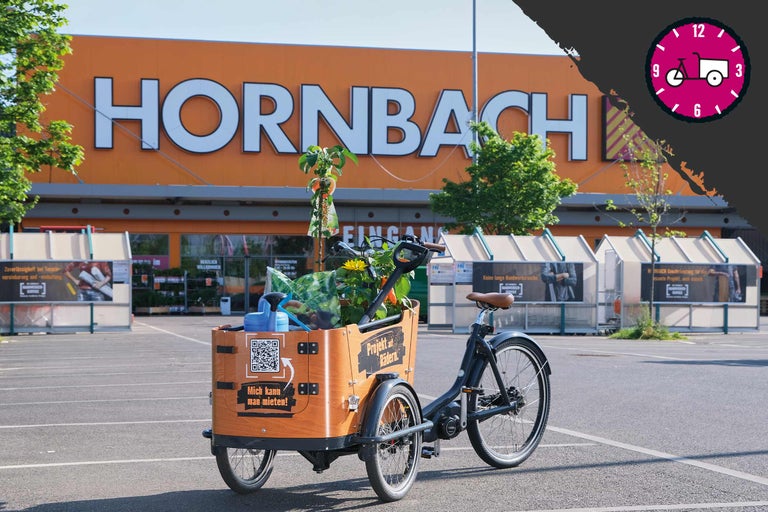 Lastenfahrrad vor einem Hornbach Markt mit Gartenzubehör