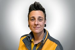 Porträt einer lächelnden Person in Arbeitskleidung