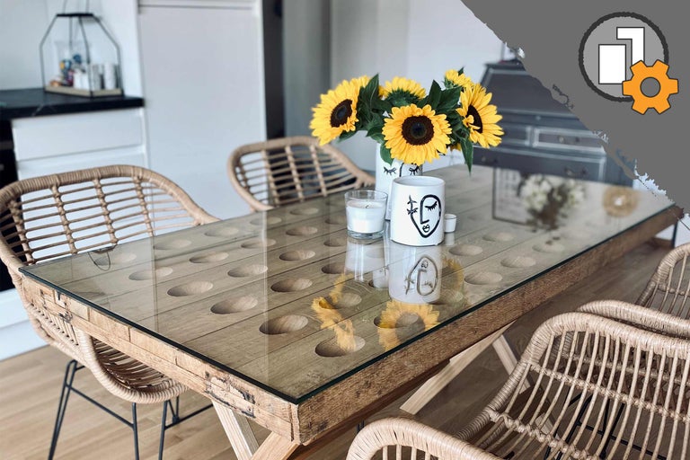 Esstisch mit Glasplatte, Holzelementen und Rattanstühlen