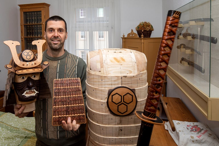 Mann präsentiert japanische Samurai Rüstung und Schwert