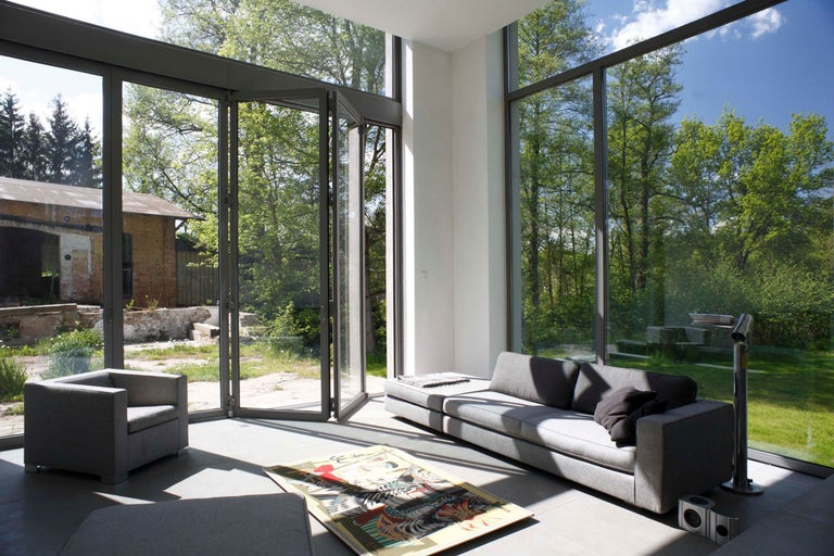 Heller Wohnraum mit großem Fenster, Couch und Sessel