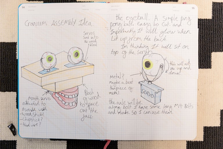 Skizze eines Schädelmontageprojekts in einem Notizbuch mit Ideen und Anmerkungen