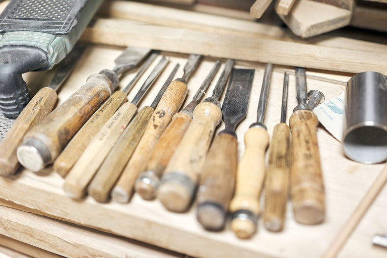 Eine Sammlung von Stecheisen mit Holzgriffen in einer Werkstatt