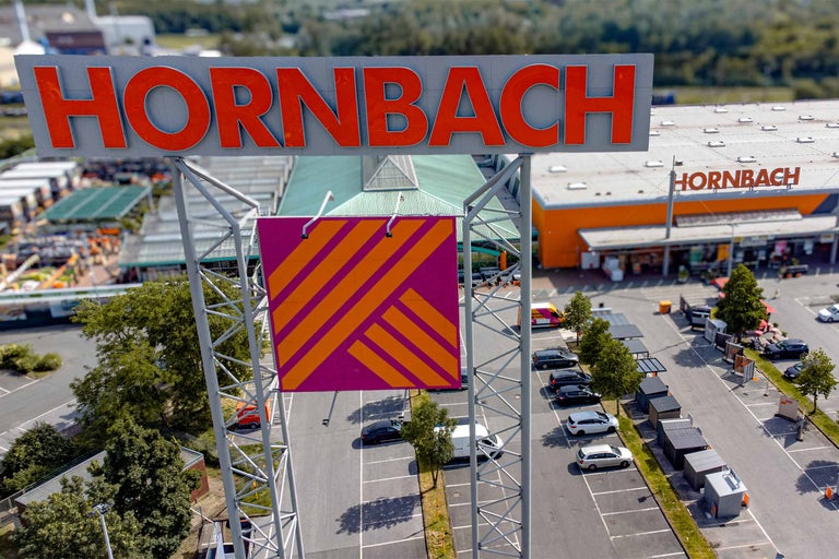 Aussenansicht eines Hornbach Baumarktes mit Eingangsbereich und Pflanzenverkauf.