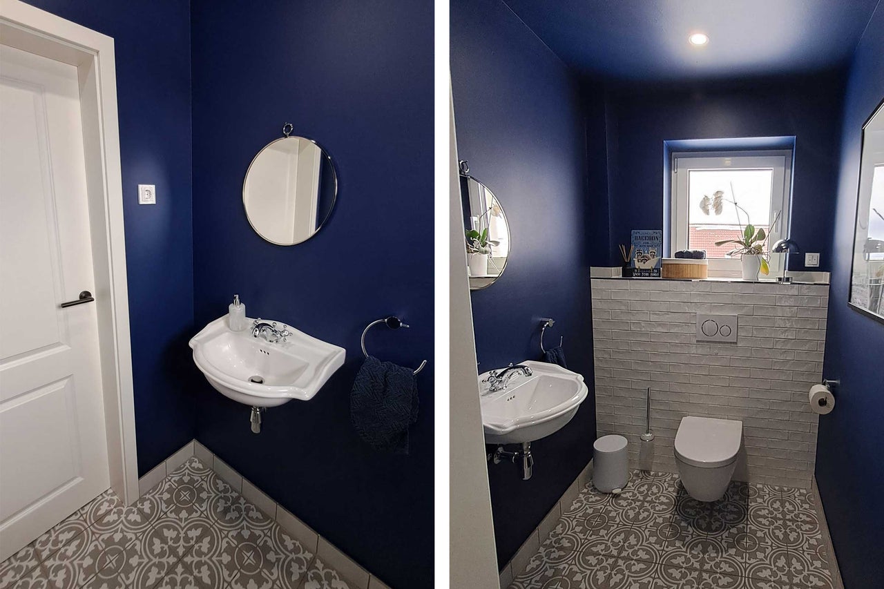 Badezimmer mit Waschbecken, Spiegel, Toilette und gemusterten Fliesen